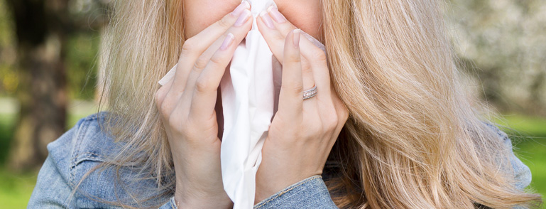 lady sneezing into tissue
