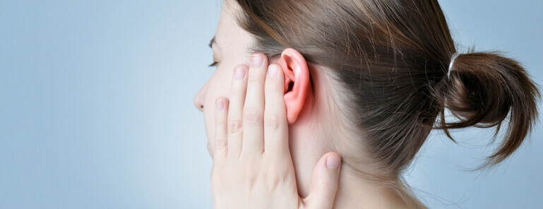 woman holding her ear